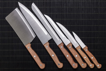 set of kitchen knifes on black mat