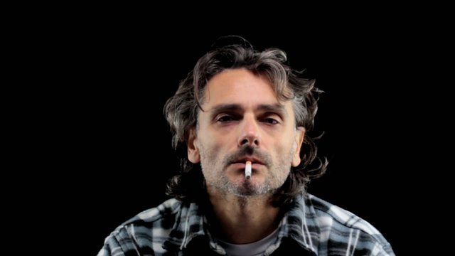 front view of a man smoking over black background