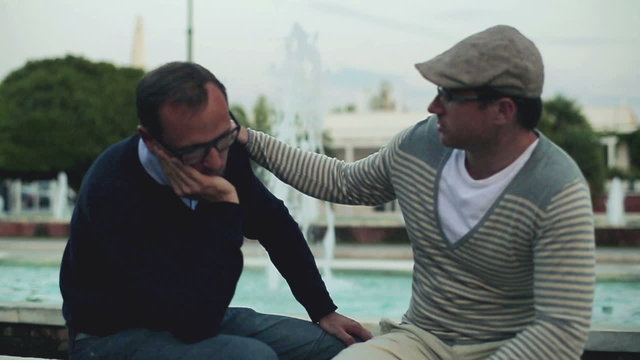Male friend comforting sad man, outdoor, slow motion 