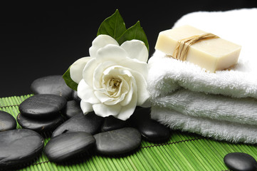 Obraz na płótnie Canvas Gardenia i kamienie z mydłem z ręcznikiem na zieloną matę