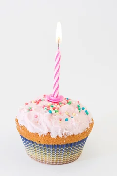 Foto Stock cupcakes rosa con candelina di compleanno accesa | Adobe Stock