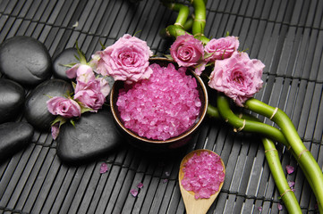 Spa sitting with rose and salt in bowl with spoon on mat