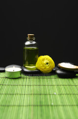 Obraz na płótnie Canvas butelkę oleju masażu i Ranunculus z zen kamienie na zielone maty