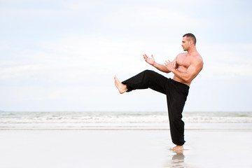 Obraz premium Man training karate at the beach