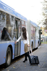 Dunkelhaarige Frau beim Einstieg in den Bus