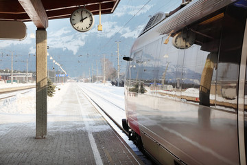 Naklejka premium Clock and train in railway station at winter