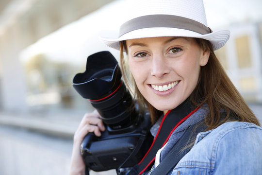 Beautiful woman photographer holding photo camera