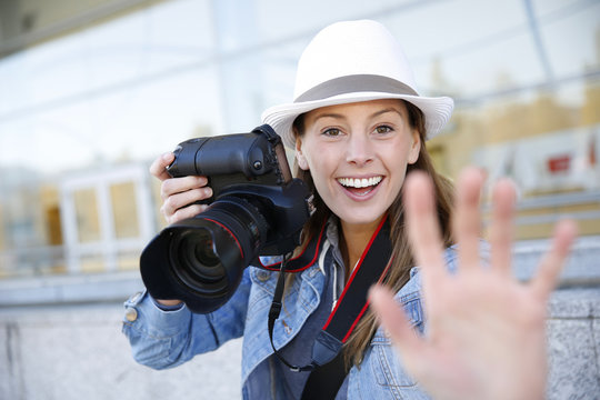Cheerful photographer showing hand towards camera
