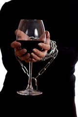 Hands tied with a chain with a glass of wine