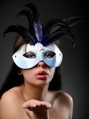 Glamour woman wearing feathered mask
