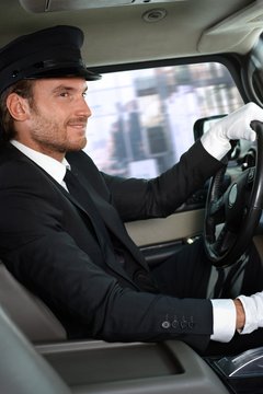 Elegant chauffeur driving luxurious car
