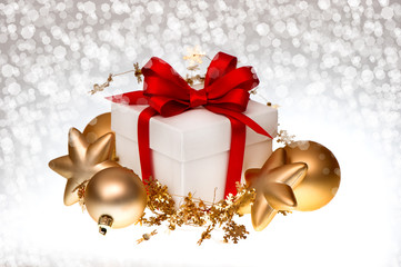 white gift box with red ribbon and golden balls