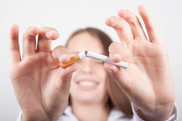 Junge Frau bricht Zigarette in zwei Stücke