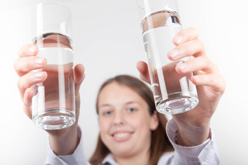 Junge Frau hält 2 Gläser Wasser