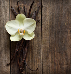 Vanilla sticks and flower on the wood background
