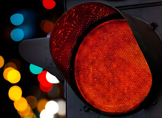Red traffic light with colorful unfocused lights on a background