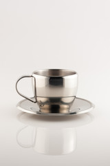 metal cup and saucer on white