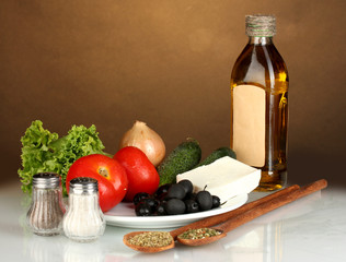 Ingredients for a Greek salad on brown background close-up