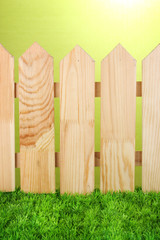 Fototapeta premium A wooden fence on a green background close-up