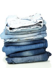 Lot of different blue jeans isolated on white