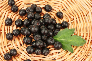 chokeberry with green leaf on wicker mat close-up