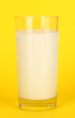 Glass of fresh new milk on yellow background