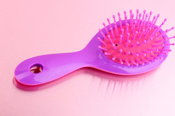 purple hair brush on pink background