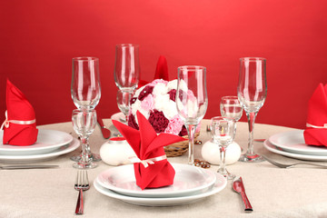 Table setting in red tones on color  background