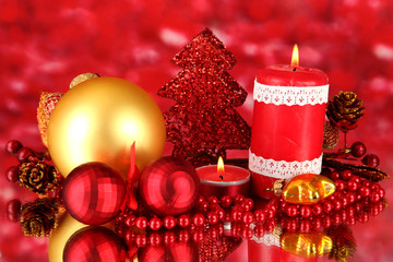 Red candle with christmas decoration on bright background