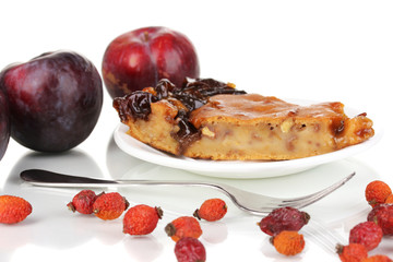 Tasty pie on plate with plums isolated on white