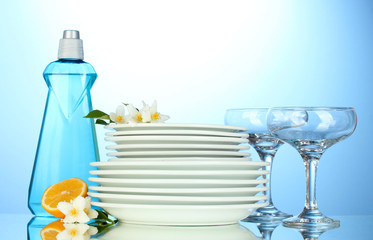 empty clean plates and glasses with dishwashing liquid, sponges