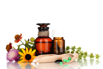 medicine bottles with tablets and flowers isolated on white