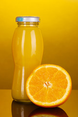 Delicious orange juice in a bottle and orange next to it