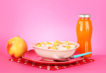 tasty dieting food and bottle of juice, on pink background