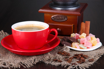 Red cup of coffee with rahat delight and coffee mill
