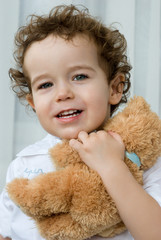 Curly-haired boy with a teddy bear