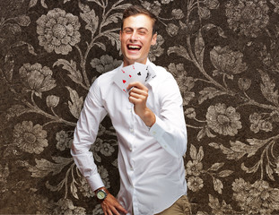 Portrait Of Young Man Showing Poker Cards