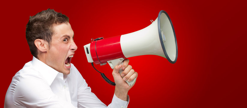 Portrait Of Young Man Shouting On Megaphone