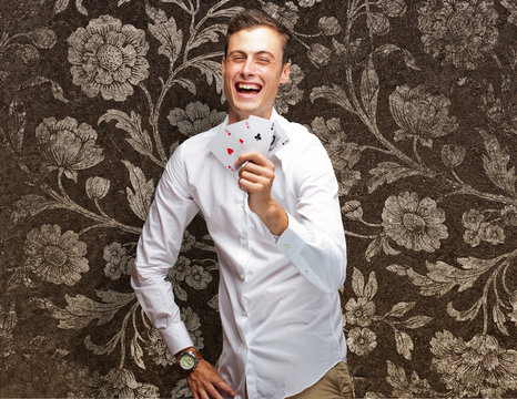 Portrait Of Young Man Showing Poker Cards