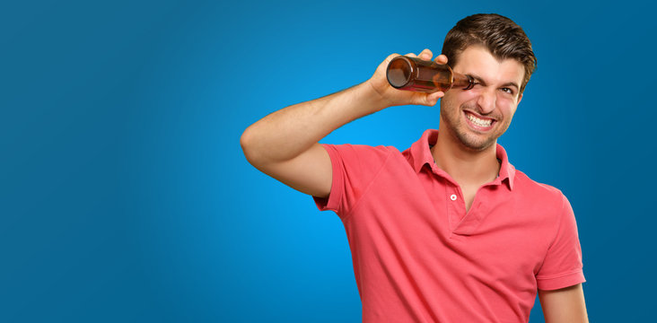man looking inside an empty bottle