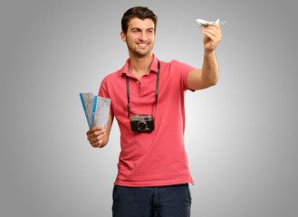 Man holding boarding pass and airplane