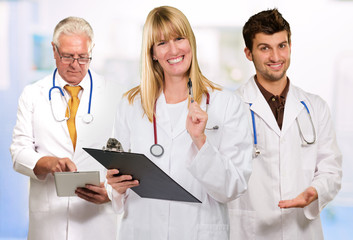 Happy Female Doctor Holding Clipboard Infront Of Male Doctor
