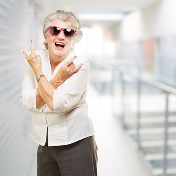 portrait of senior woman smiling and wearing sunglasses at moder