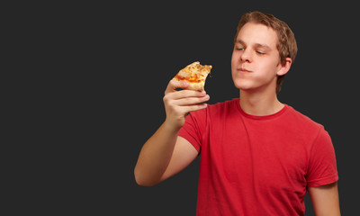 portrait of a young man eating pizza