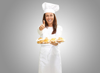 Woman chef holding baked food