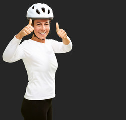 Woman wearing helmet showing thumb up