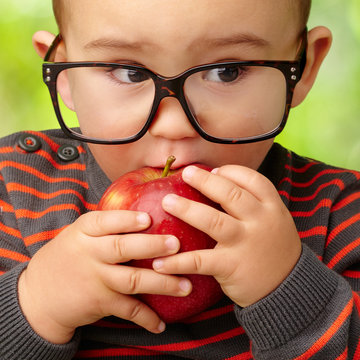 Portrait Of Baby Boy Eating Red Apple