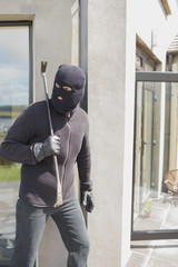 Burglar hiding behind wall