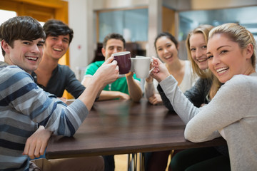Students sitting clinking cups