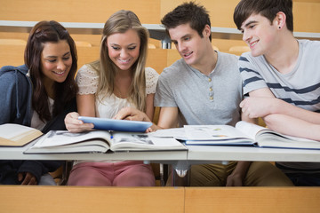 Students sitting looking at tablet pc and smiling